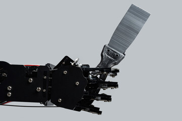 Real robotic hand with putty knife. Concepts of Artificial intelligence development or job...