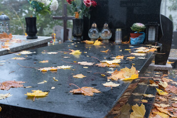 Warsaw, Poland - October 24, 2023: Graves in the cemetery on a cloudy, foggy day. Weather for All Saints' Day. Candles and flowers on graves. - obrazy, fototapety, plakaty