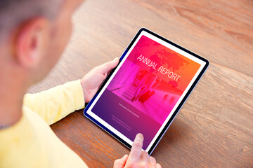 Man reading electronic company's annual report on digital tablet