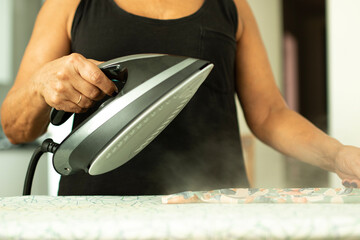 woman ironing clothes, showing steam at full power