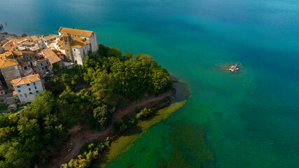 Aerial view of the collegiate church of Santa Maria Assunta in the historic center of Anguillara,in the metropolitan city of Rome, Italy. It's a Catholic church located on the shores of Lake Bracciano - obrazy, fototapety, plakaty