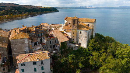 Aerial view of the collegiate church of Santa Maria Assunta in the historic center of Anguillara,in the metropolitan city of Rome, Italy. It's a Catholic church located on the shores of Lake Bracciano - obrazy, fototapety, plakaty