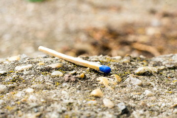 A match, a hand with a matches against the background of old garages in city.