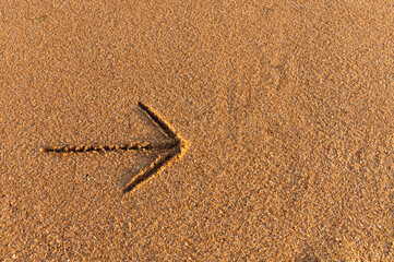 An arrow indicating the direction to the right, an inscription on the sand near the ocean or sea...