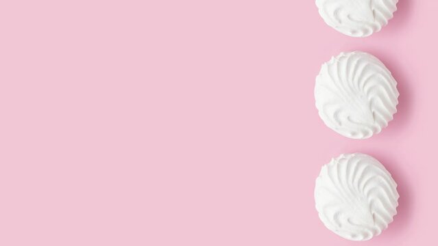 Soft white vanilla zephyr on light pink table. Pastel color. Video with empty space for the text