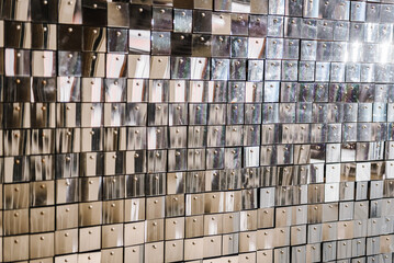 Wall is made of square glittering sequins. Silver glitter sparkles on background. Space with flickering and glittering metallic particles. Decor and interior decoration. Place for text. Closeup.