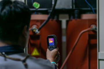 Professional Electrician use thermal infrared camera or thermometer scanning electrical system for preventive maintenance,Industrial thermography,Thermal image of power electric.