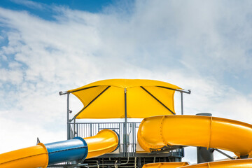 Yellow water slide with a yellow sun sail on a summer day