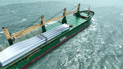 Wind Turbine on Ship, Transportation of blades for wind turbines on a cargo ship. Heavy load carrier on cargo ship loaded with Electric Wind Turbine Blades.