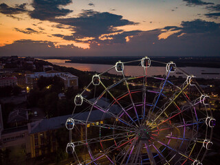 Beautiful sunset over the city with a lighted Ferris wheel.