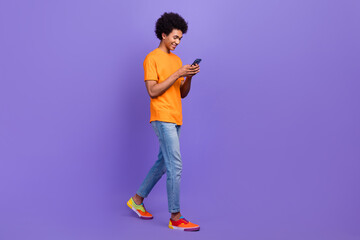 Full length cadre of young guy trading bitcoin emoney online wear casual outfit millionaire use phone isolated on purple color background
