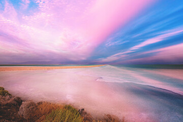 Seascape in the morning. Pink sunrise over the Dead Sea. View of Jordan from Israel