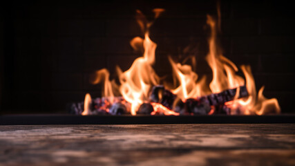Naklejka premium Closeup burning fire in a fireplace on marble table with blurred background. High quality photo