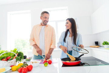 Photo of cute sweet wife husband enjoying morning cooking together indoors apartment kitchen