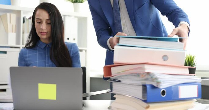 Businessman and businesswoman work with folders of documents and communicate. Helpfulness and professional teamwork concept