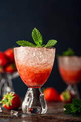 Fresh cocktail with crushed ice, strawberry and mint on old rusty blue metal table. Summer cold drink concept with copy space