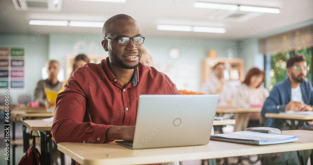 Aufkleber adult education center: african student learning in classroom and smiling, using laptop to write dow