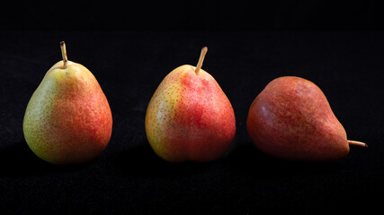 Red and yellow pears on a black background.