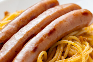 ウインナーソーセージ(ミートソースパスタにのせられた状態)のアップ。
