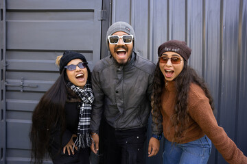 Happy indian group of friends wearing winter clothes shouting having fun isolated on grey background. - obrazy, fototapety, plakaty