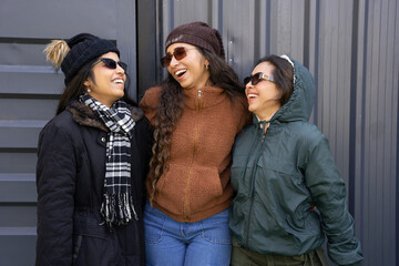 Group of young indian girls enjoying vacation wearing warm winter clothes with cap & sun glasses