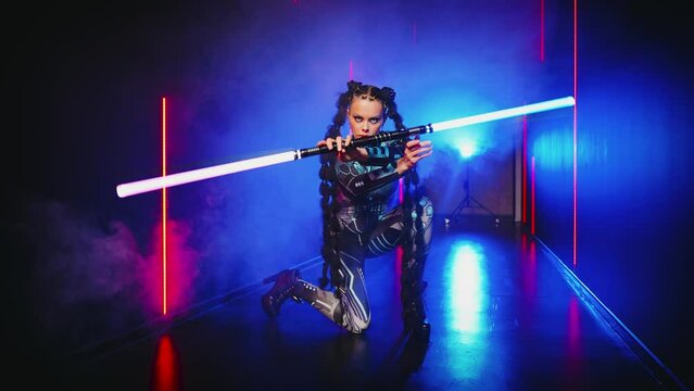 Fashion model posing Fantasy cyborg woman creative robot costume metal body creative makeup, cyberpunk style braid. Sexy alien girl in virtual reality war warrior future vr laser sword staff in hands 