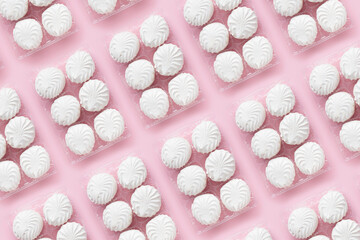 Packs of soft white vanilla zephyr on light pink table. Banner with pattern