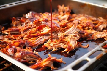 carolina pulled pork on a stainless grill rack marinating in vinegar sauce