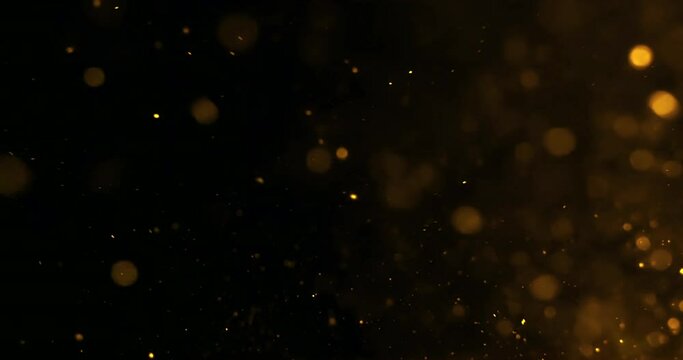 gold glow glittering particles bokeh tail transition sparkle effect on black background, holiday happy new year