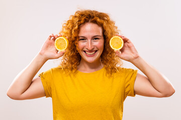 Beautiful ginger woman is holding  slices of lemon.