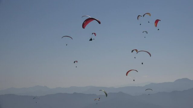 Large numbers of paragliders search for the best thermals in the skies over Pokhara, a popular destination in Nepal for outdoor activities and adventure sports.