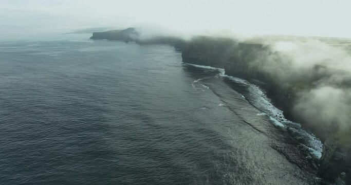 Flying in the clouds above the Cliffs of Moher in 4k