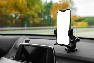 Phone holder with white screen on car dashboard.
