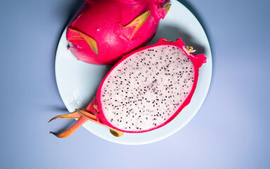 Delicious cut dragon fruit (pitahaya) on blue background, flat lay. 