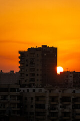 Fototapeta premium Sun about to set completely. Sunset in Africa. Yellow and orange open skies. Silhouette of an african terrace watching the sunset.