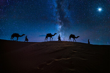 Christmas Jesus birth concept - Adoration of the Magi, Three Wise Men, Three Kings, and the Three biblical Magi with camel silhouettes journeying in sand dunes of desert follow Bethlehem star at night - obrazy, fototapety, plakaty
