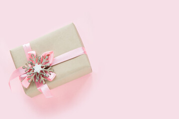 Christmas gift box for girl with pink ribbon and snowflake on pink background. Greeting card for Xmas holiday.