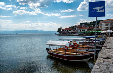 Sail boats beside dock on Ohrid lake with old town Ohrid in the background. Ohrid, North Macedonia