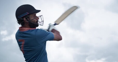 Low Angle Slow Motion Action Footage on a Cloudy Day. Portrait of an Athletic Indian Cricket Player Striking the Ball with a Bat. Batsman From a Blue Team Sends the Ball to the Outfield - Powered by Adobe