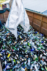 Shot from above of a garbage truck with a huge number of glass bottles sent from waste recycling station for recycling