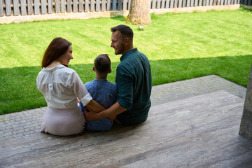 Happy family sits on the terrace of a country house