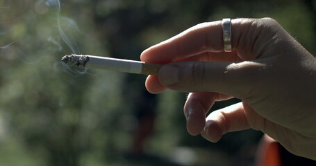 Close-up hand holding cigarette captured
