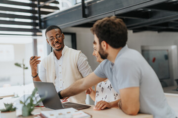 Three young mutliracial entrepreneurs discussing business idea and analyzing business plan