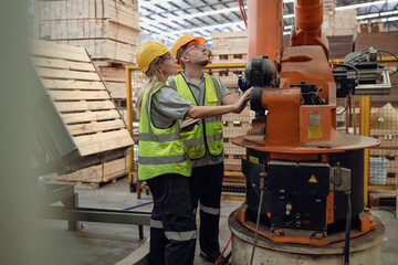 Caucasian engineer team standing hardwood furniture factory examining production machine for...