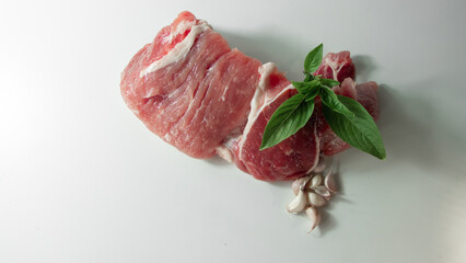 Pork with basil on a white background