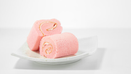 Strawberry roll cake on white background. Rose strawberry cake placed on a plate