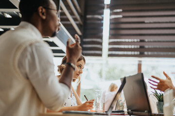 In a modern corporate office, a diverse group of business professionals collaborate, analyze data, and discuss innovative ideas, driving successful outcomes.