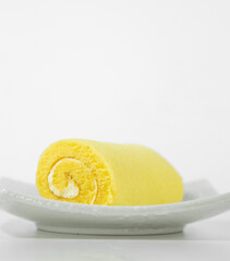 Banana roll cake, strawberry roll cake, cow's milk roll cake and orange roll cake on a white crate background.