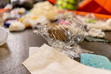 Close-up shot of plastic containers of bottles and bags located on a waste sorting line at waste...
