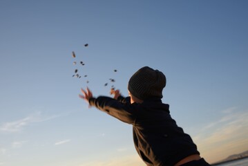 Bambino che lancia sassi (e le sue speranze) verso il cielo, verso l'orizzonte: verso il futuro!